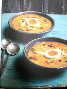 2 bowls of corn soup garnished with a boiled egg and spring onions